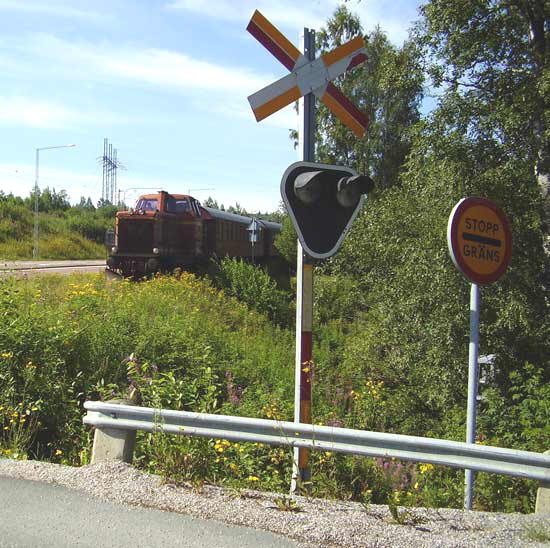 T21 77 med OKBv-tågsätt nalkas övergången vid Stockvik nedre.